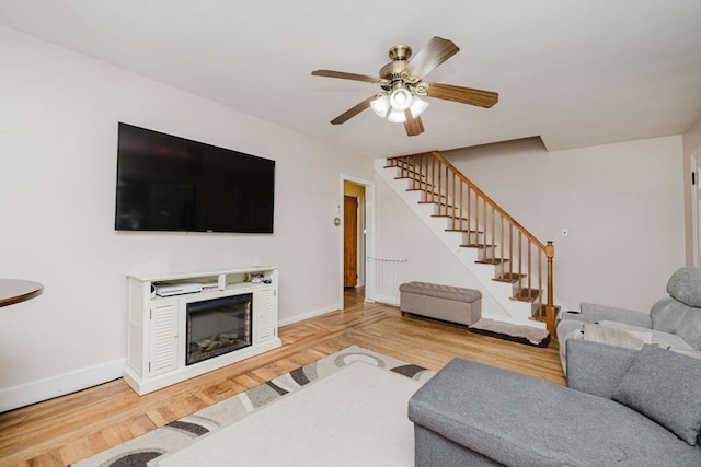 51 Jette St, Swansea, MA 02777 - living area with stairs, ceiling fan, wood finished floors, and a glass covered fireplace