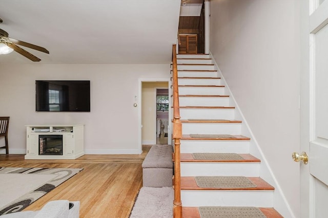 51 Jette St, Swansea, MA 02777 - stairway featuring a ceiling fan, wood finished floors, and a glass covered fireplace