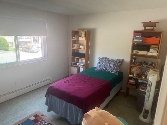 bedroom featuring carpet floors and a baseboard heating unit