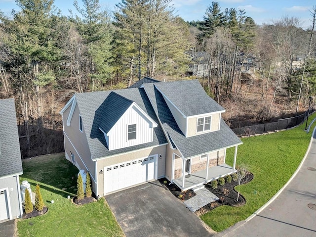 view of front of house featuring covered porch, a garage, and a front yard