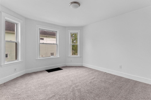 empty room with baseboards and carpet