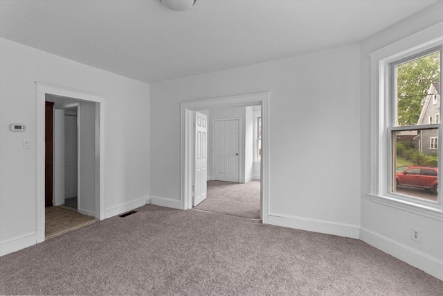 carpeted empty room featuring baseboards