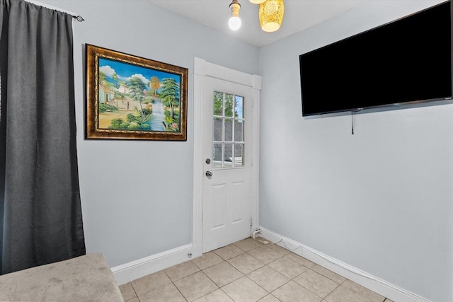 doorway to outside with baseboards and light tile patterned floors