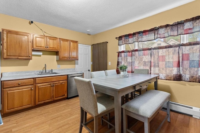 dining space with a textured ceiling, light wood-type flooring, and a baseboard radiator