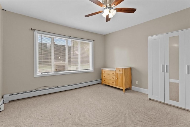 unfurnished bedroom with baseboard heating, carpet, a ceiling fan, and baseboards