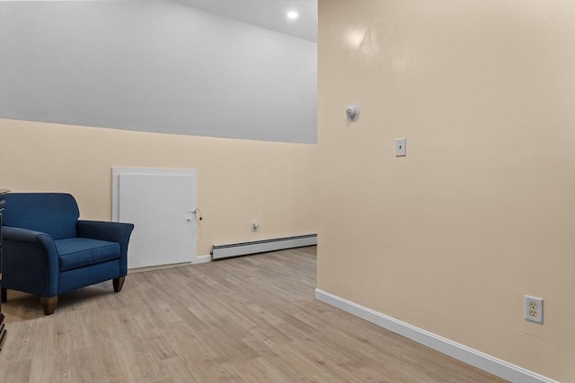 sitting room with a baseboard heating unit, light wood-style floors, baseboards, and recessed lighting