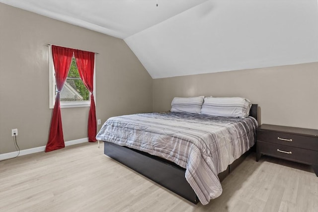 bedroom with wood finished floors, vaulted ceiling, and baseboards