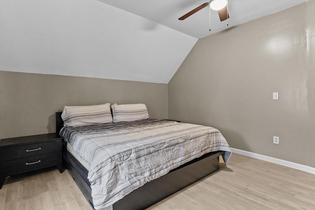 bedroom with light wood-style flooring, lofted ceiling, baseboards, and a ceiling fan