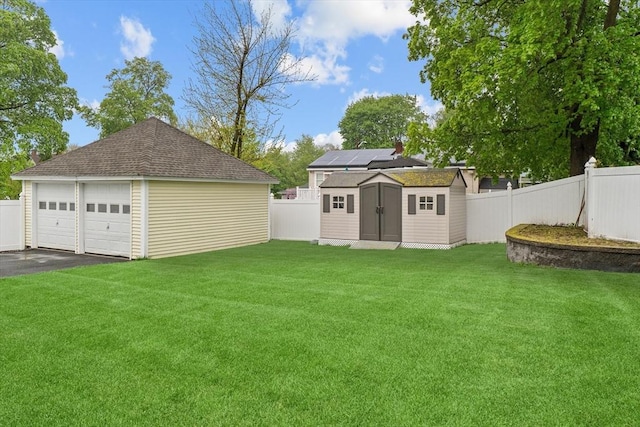view of yard with an outdoor structure, a garage, and a shed