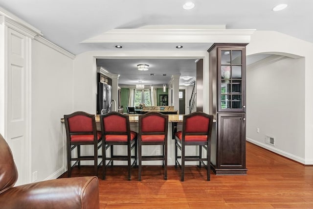 8 Knight Rd, Framingham, MA 01701 - indoor bar featuring stainless steel refrigerator with ice dispenser, arched walkways, wood finished floors, recessed lighting, and baseboards