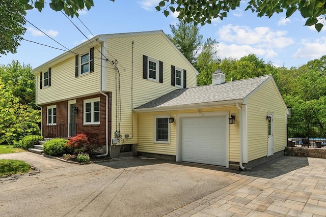 8 Knight Rd, Framingham, MA 01701 - view of front of house featuring driveway, an attached garage, brick siding, roof with shingles, and a chimney