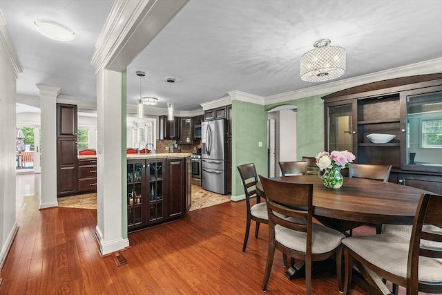 8 Knight Rd, Framingham, MA 01701 - dining room with dark wood-style floors, arched walkways, ornamental molding, and healthy amount of natural light