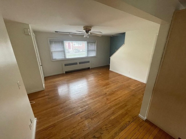 interior space with ceiling fan, light wood-type flooring, and radiator heating unit