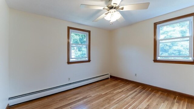 empty room with a baseboard radiator, ceiling fan, and light hardwood / wood-style floors