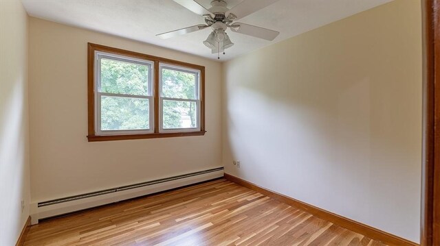 spare room with a baseboard heating unit, light hardwood / wood-style floors, and ceiling fan