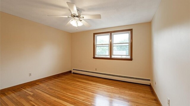 empty room with a baseboard heating unit, light hardwood / wood-style floors, and ceiling fan