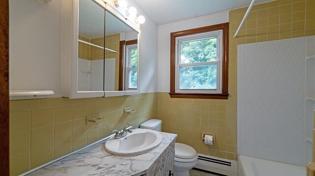 full bathroom with toilet, tiled shower / bath, tile walls, a baseboard radiator, and vanity