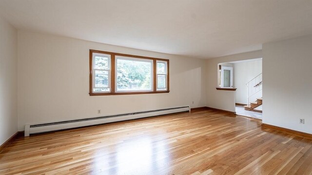 empty room with a baseboard radiator and light wood-type flooring