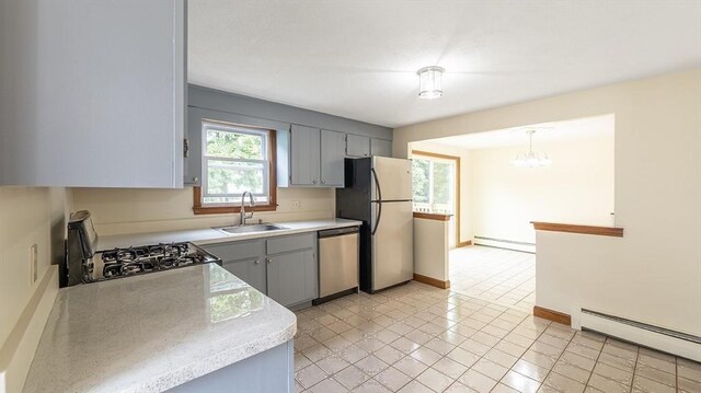 kitchen with a baseboard radiator, stainless steel appliances, gray cabinets, and sink