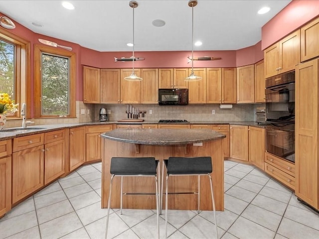 kitchen featuring backsplash, a sink, black appliances, and a center island