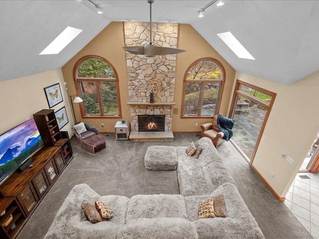 living area featuring a skylight, baseboards, carpet, and rail lighting