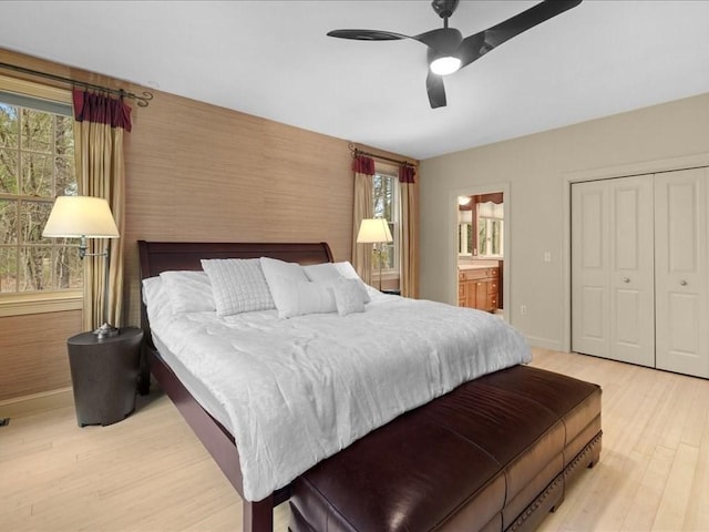 bedroom featuring baseboards, multiple windows, and light wood finished floors