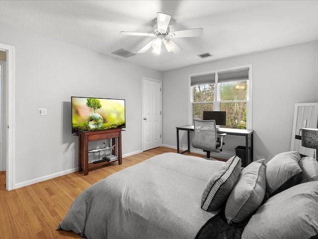 bedroom featuring baseboards, wood finished floors, and visible vents