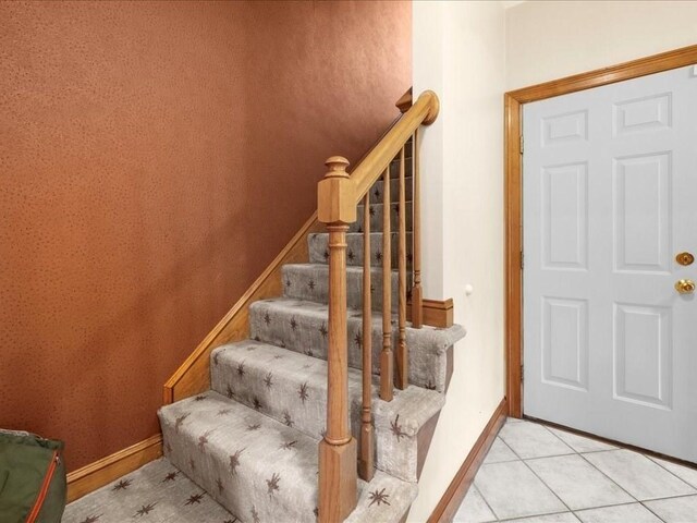 stairs featuring baseboards and tile patterned flooring