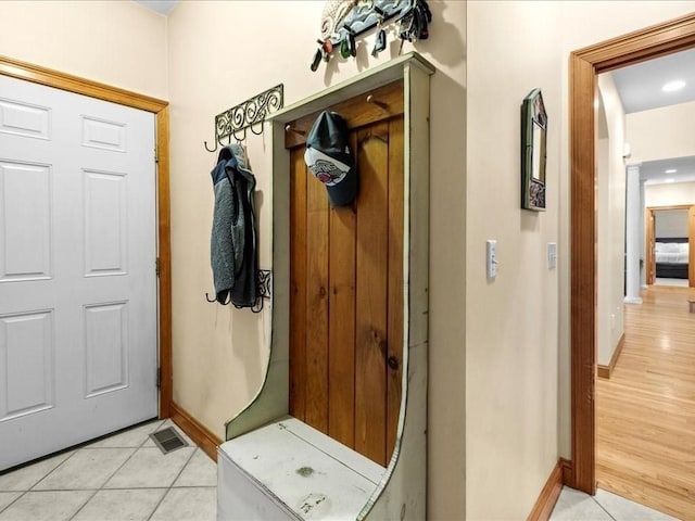 mudroom with baseboards, visible vents, and light tile patterned floors