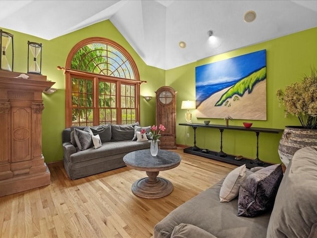 living area with high vaulted ceiling and wood finished floors