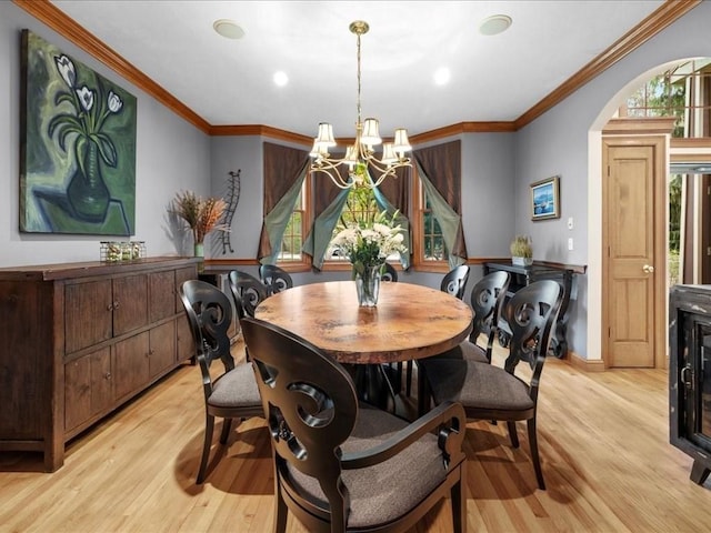 dining area with crown molding, baseboards, a chandelier, and light wood-type flooring