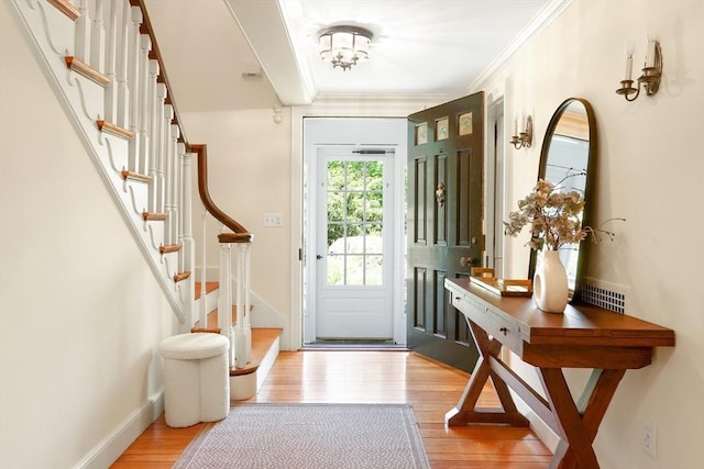 entryway featuring stairs, crown molding, baseboards, and wood finished floors