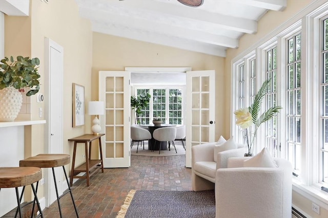 sitting room featuring lofted ceiling with beams, french doors, and brick floor