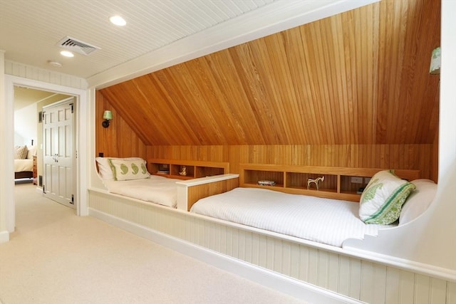 bedroom with visible vents, lofted ceiling, wood walls, wooden ceiling, and carpet flooring