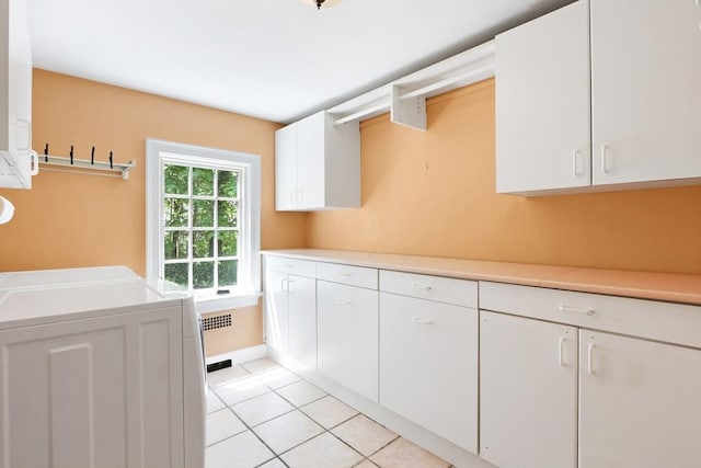 laundry room featuring cabinet space and light tile patterned flooring