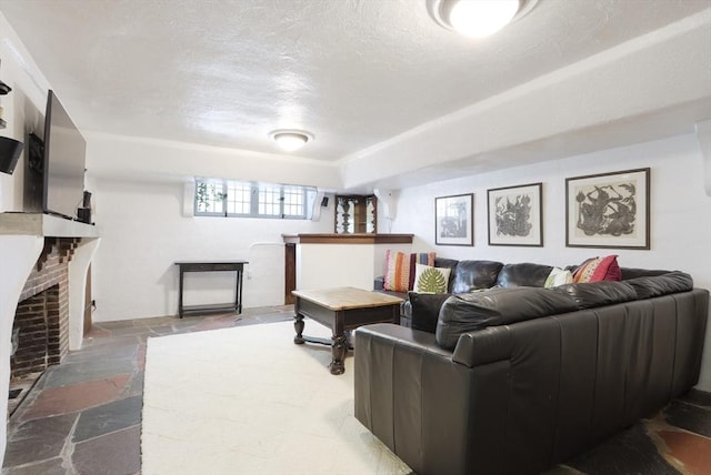 living room with a textured ceiling, stone tile floors, and a fireplace