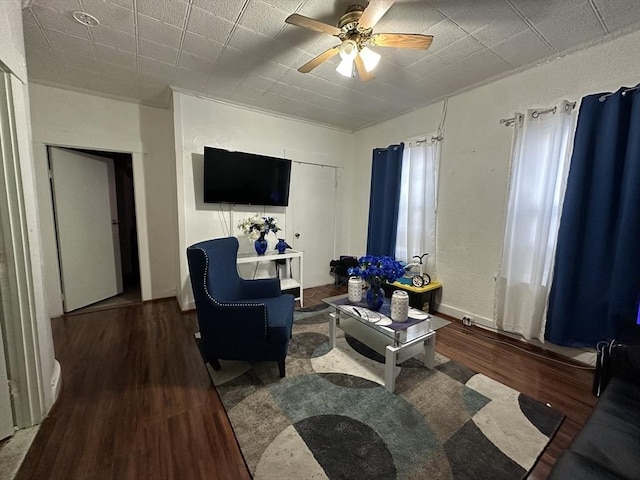 living room featuring ceiling fan and dark hardwood / wood-style flooring