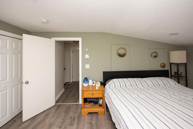 bedroom with vaulted ceiling and wood finished floors