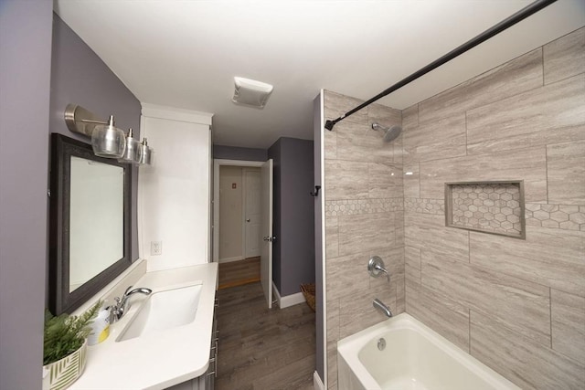 bathroom featuring wood finished floors, shower / tub combination, vanity, and baseboards