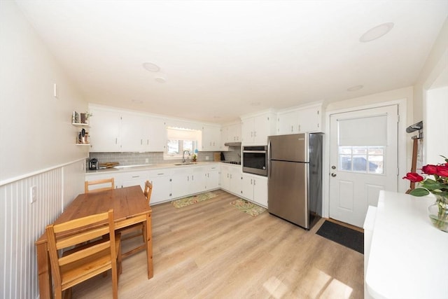 kitchen with light countertops, appliances with stainless steel finishes, a sink, and white cabinetry