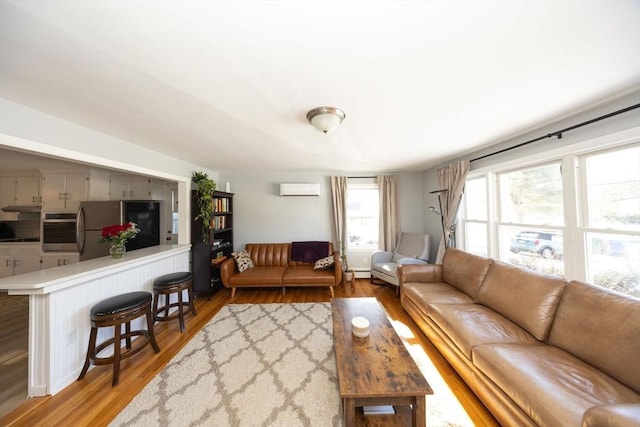 living room with a baseboard radiator, wood finished floors, and a wall mounted air conditioner