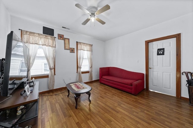 living area featuring wood finished floors, ceiling fan, and baseboards