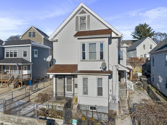 view of front facade featuring a fenced backyard, a shingled roof, and entry steps