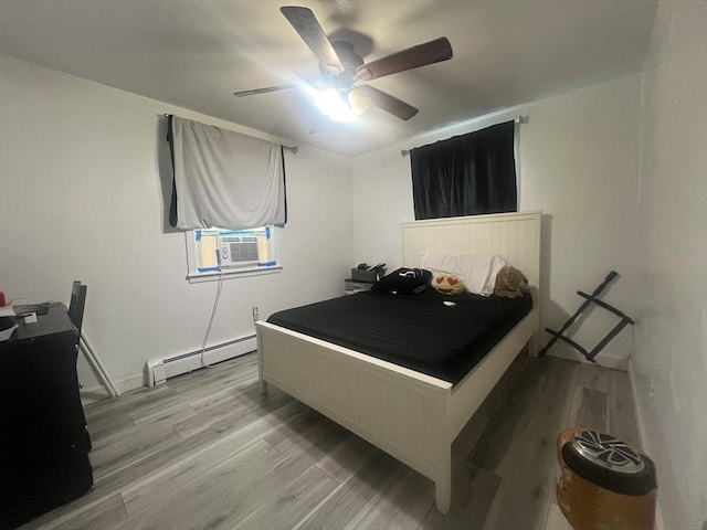 bedroom featuring cooling unit, ceiling fan, wood finished floors, and a baseboard radiator