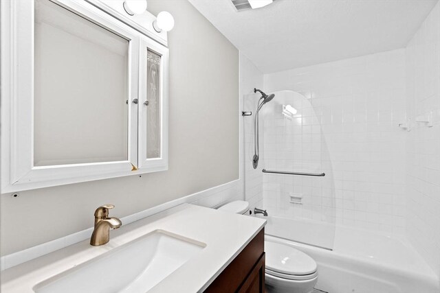 bathroom with vanity, shower / bath combination, and toilet