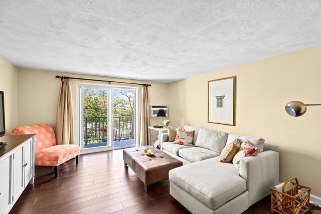 living area with dark wood-style flooring and a textured ceiling