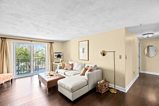 living area featuring hardwood / wood-style floors, baseboards, and a textured ceiling