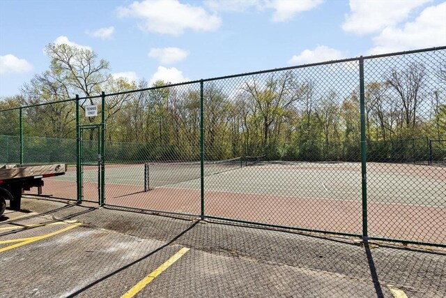 view of tennis court featuring fence