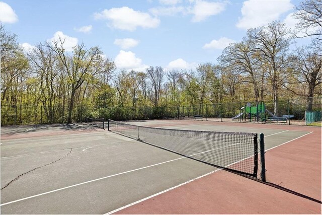 view of sport court featuring community basketball court, fence, and playground community