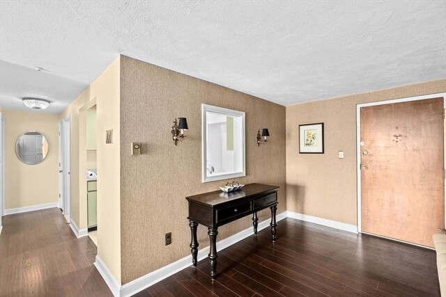 hall featuring baseboards, a textured ceiling, and dark wood-style flooring